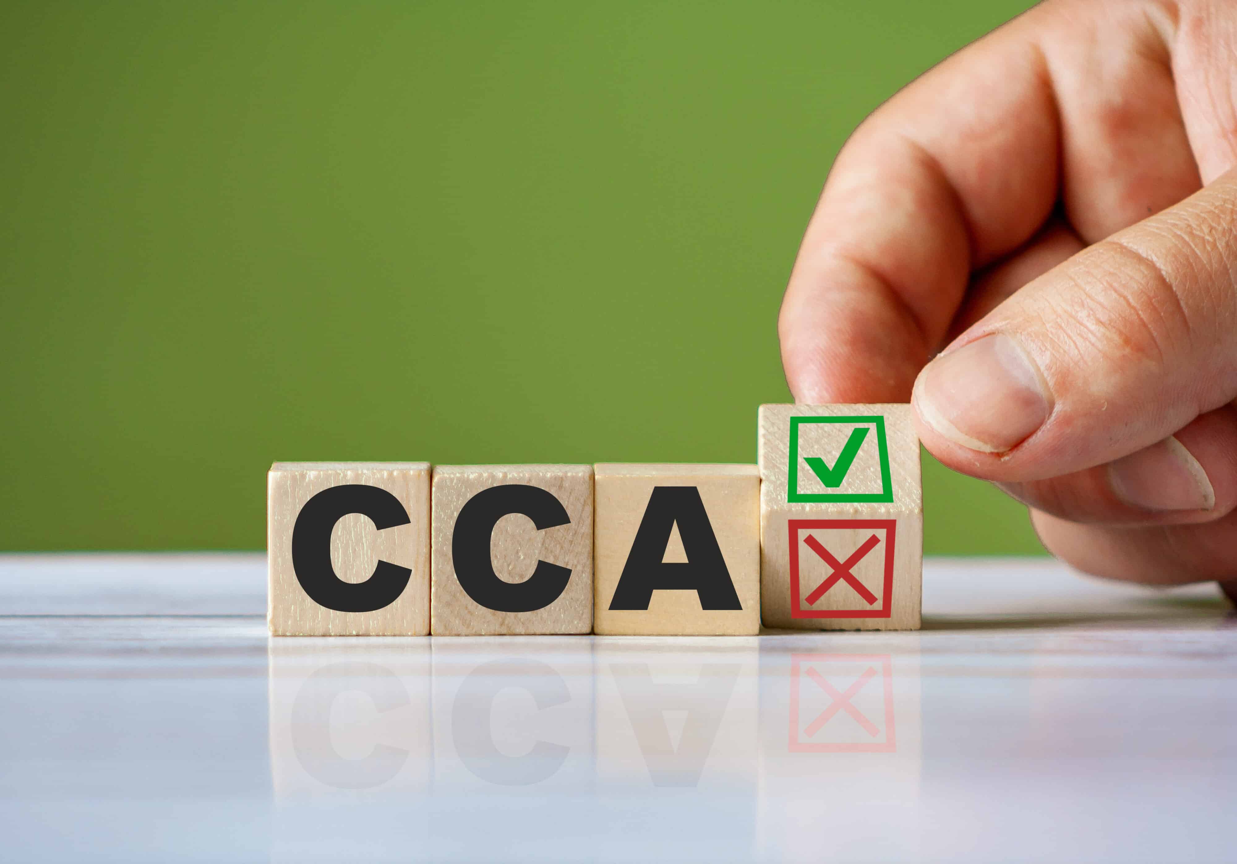 The hand turn wooden block with red reject X and green confirm tick as change concept of CCA. Word CCA Current Cost Accounting conceptual symbol.